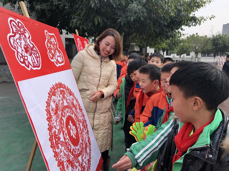 剪纸社团的指导老师游琴舒为孩子们讲解剪纸作品的制作过程，引得孩子们连连赞叹